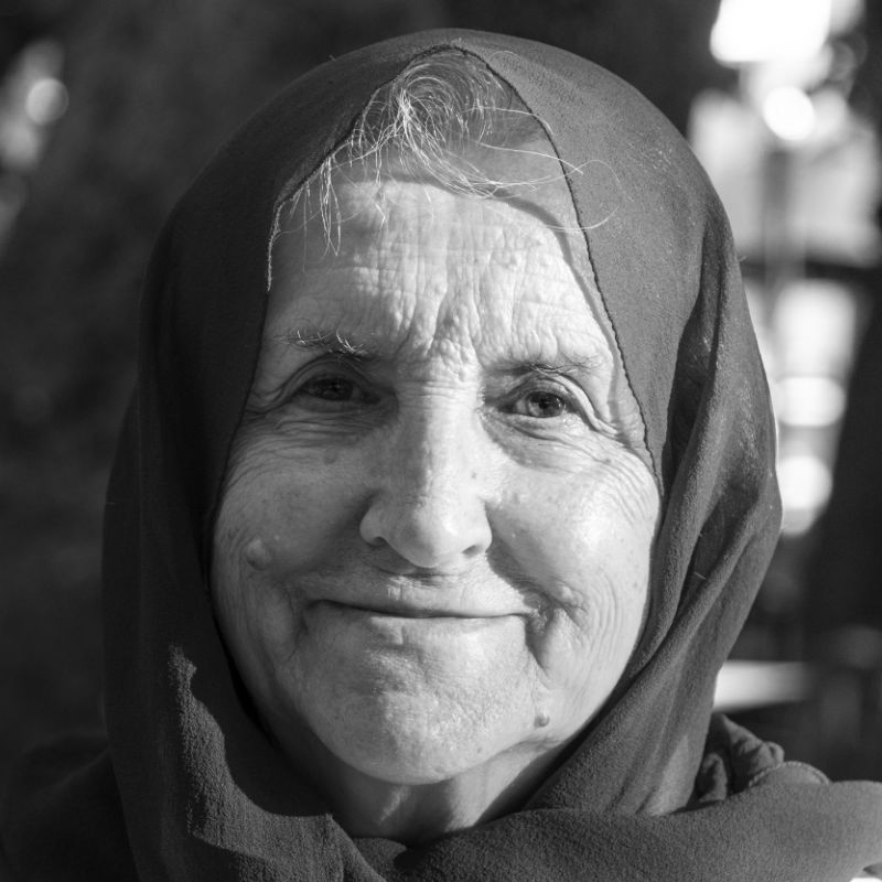 Portrait of old muslim woman wearing red hijab. Old woman smiling and looking at camera